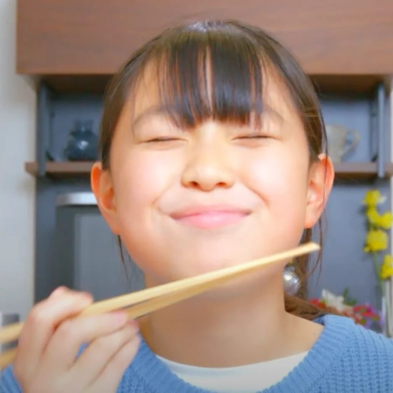 サーモンを食べて笑顔になる女の子